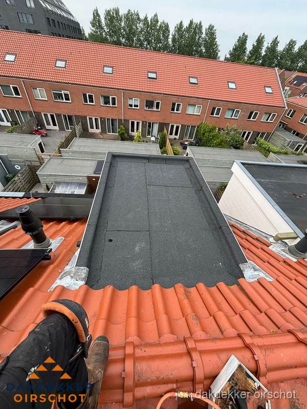 Bitumen dak reparatie op plat dak tussen dakpannen in Oirschot