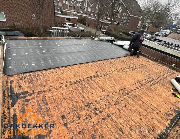 Dakdekker legt onderlaag op plat dak met houten constructie in Oirschot