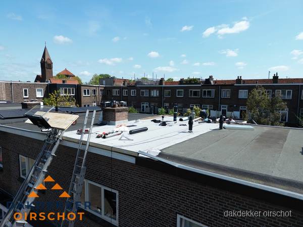 Dakdekkers aan het werk op plat dak in Oirschot