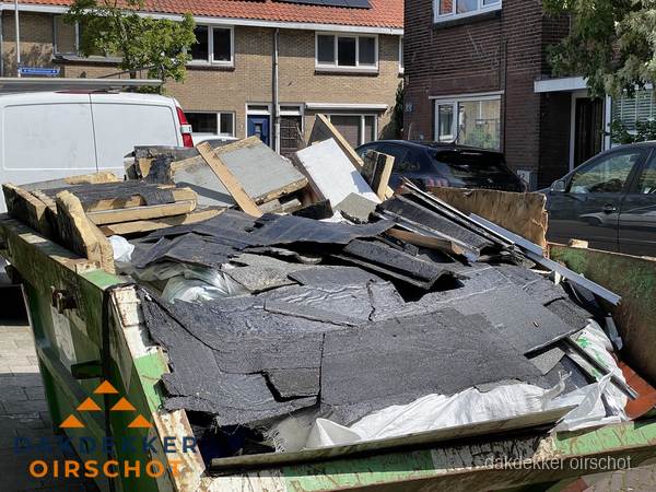 Afvalcontainer met gesloopt dakmateriaal tijdens dakkapel renovatie in Oirschot