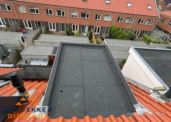 Plat dak met bitumen bedekking naast dakkapel in Oirschot